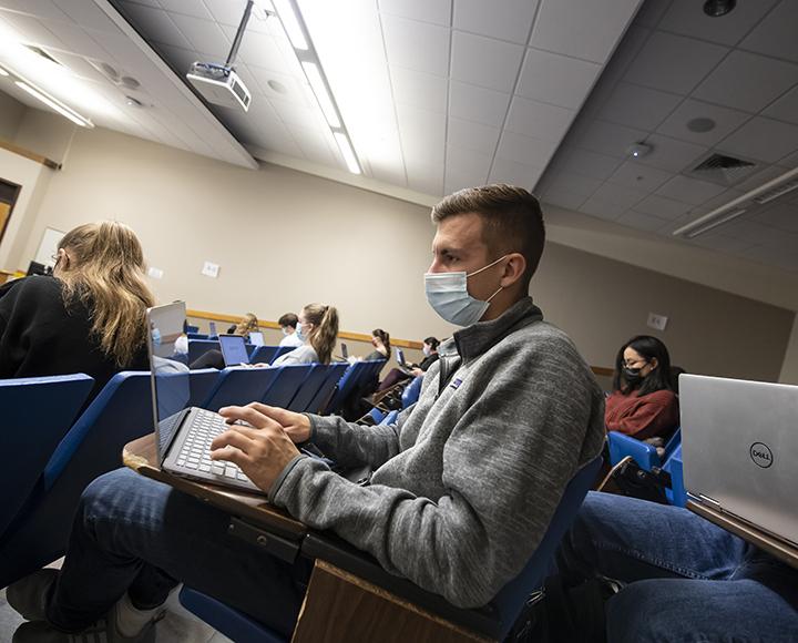 Matthew Starinksy taking notes on his laptop while attending a course