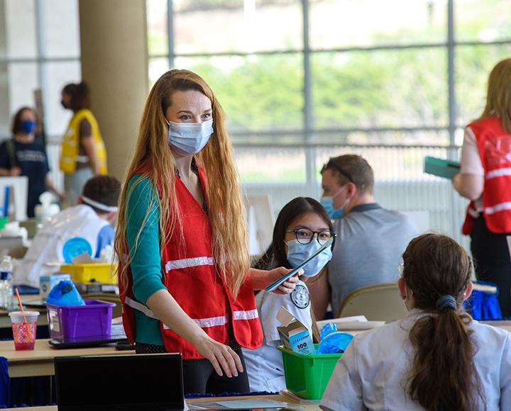 a woman with long red hair at a vaccination station