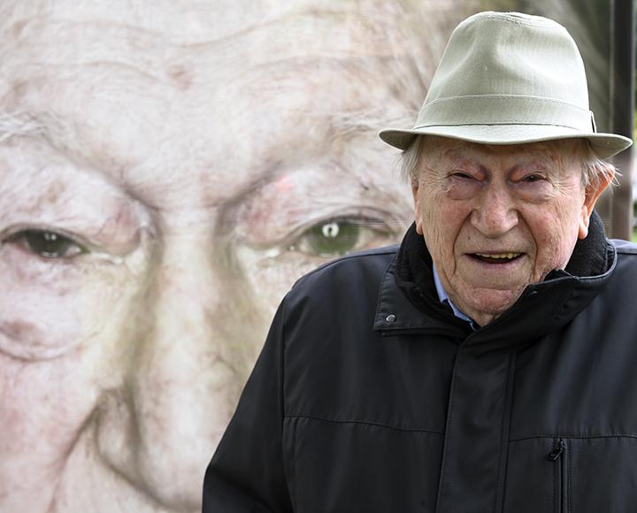 Oscar Singer in front of the "Lest We Forget" exhibit