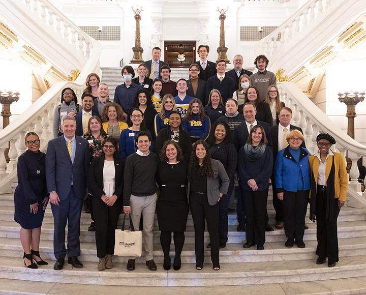 Pitt faculty and students posing for photo on stairs