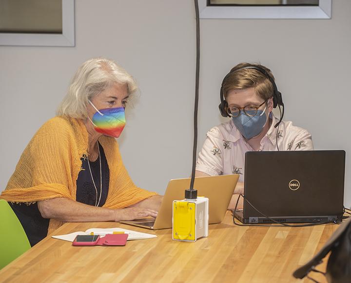 Kit Ayers and Angie Bedford-Jack watch a livestream on a laptop