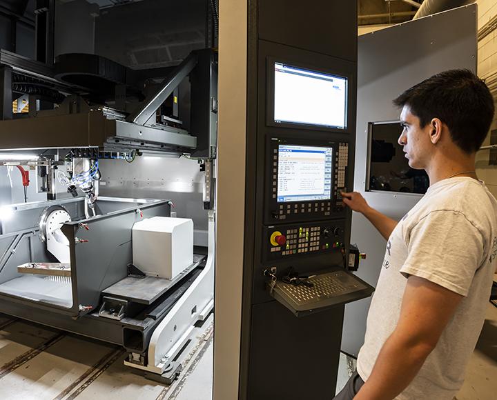 Jimenez in front of a large screen near the printer