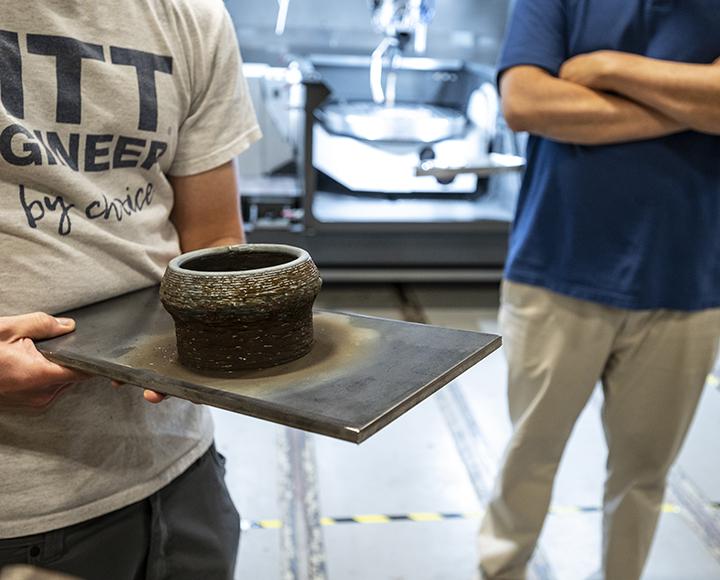 Jimenez holding a bowl-like object on a plate