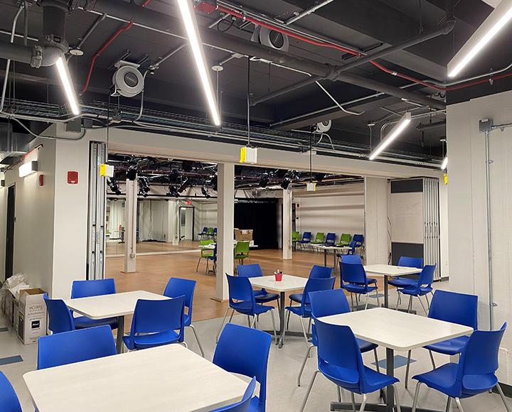 an area with tables, chairs and a performance space
