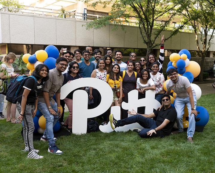 dozens of students around a Pitt sign