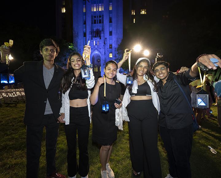 five students posing with lanterns