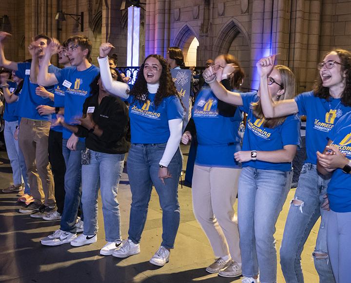 Pitt Alumni Student Network students lead the crowd in a chorus of Sweet Caroline during the Blue and Gold Bash on Friday evening.