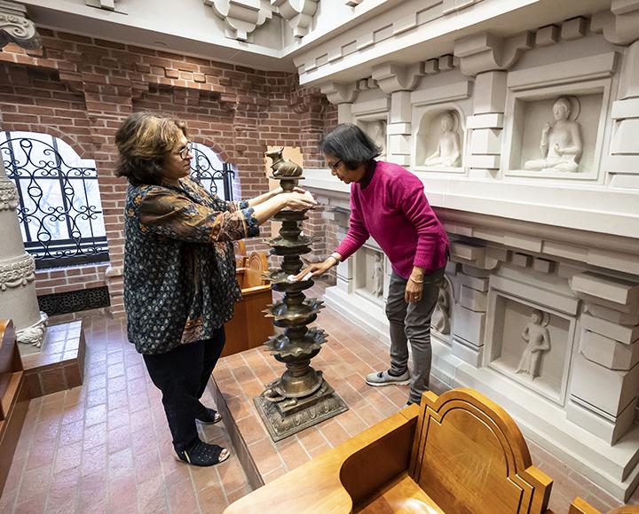 two people decorating a statue