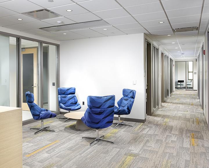 Blue chairs sit in a common area in Salk Hall