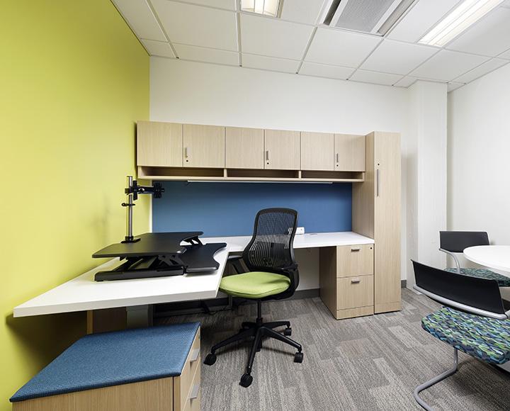 An office space with cabinets and a standing desk