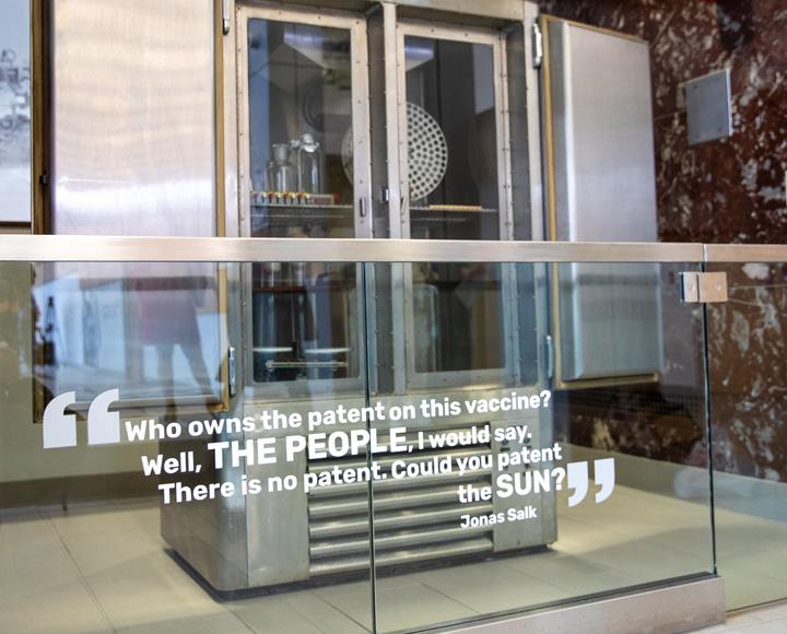 a large metal and glass incubator with a Salk quote in front of it "Who owns the patent on this vaccine? Well, the people, I would say. There is no patent. Could you patent the sun?"
