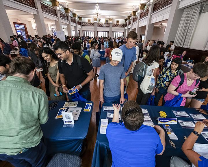 dozens of students line up in front of a table