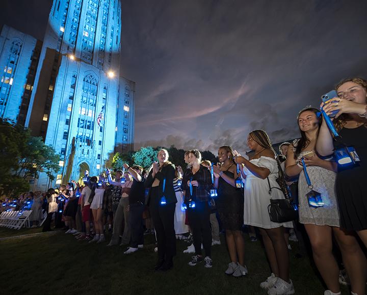a long row of students with glowing lanterns near the Cathedral