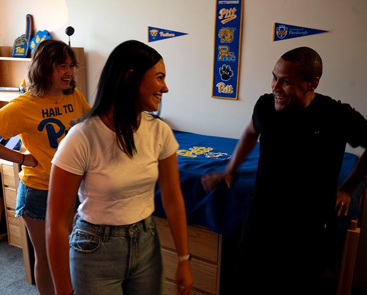 Two students laugh in a dorm with the video director