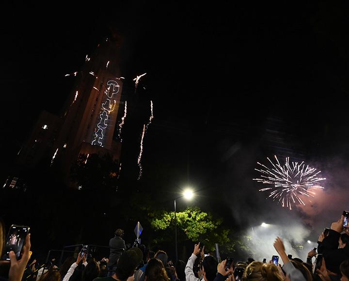 Lasers spell out Pitt as fireworks explode in the sky around the Cathedral of Learning