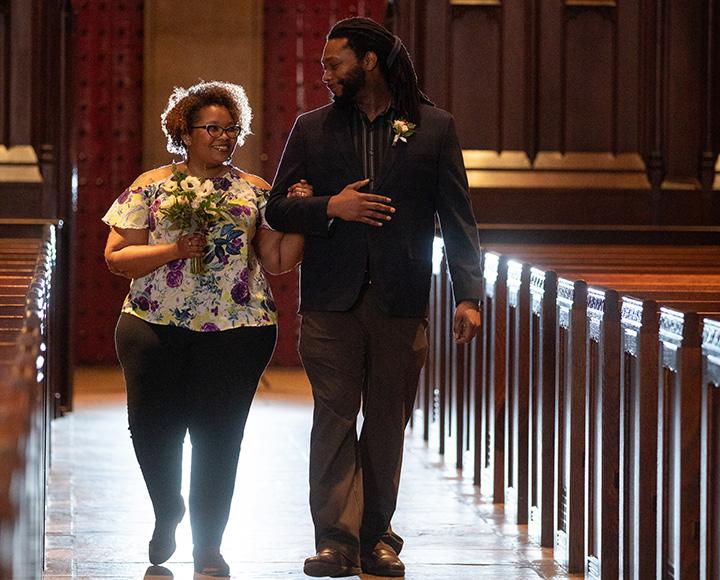 A couple walks down the aisle at Heinz Chapel