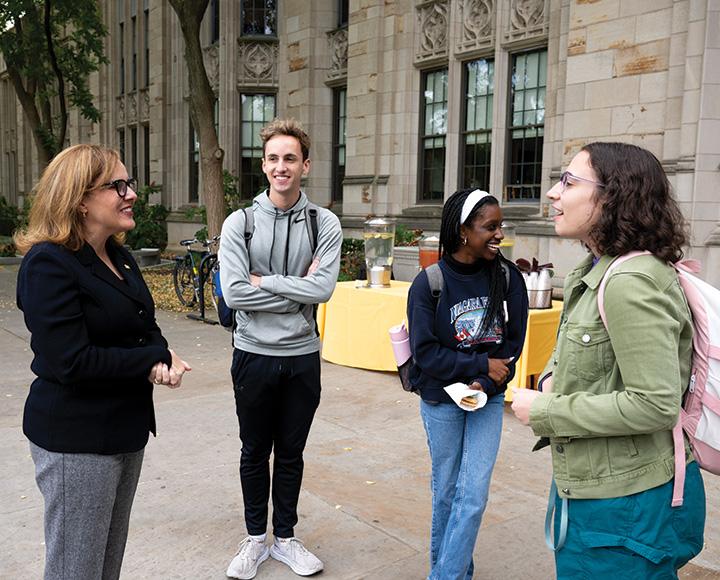 Gabel talks with three students