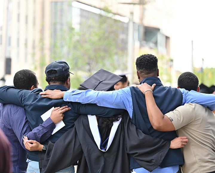 The back of a family taking a picture, with their graduate in the center