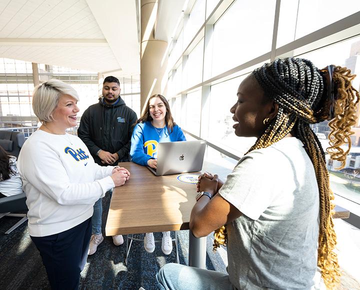 Panzella talks to students at a high-top table