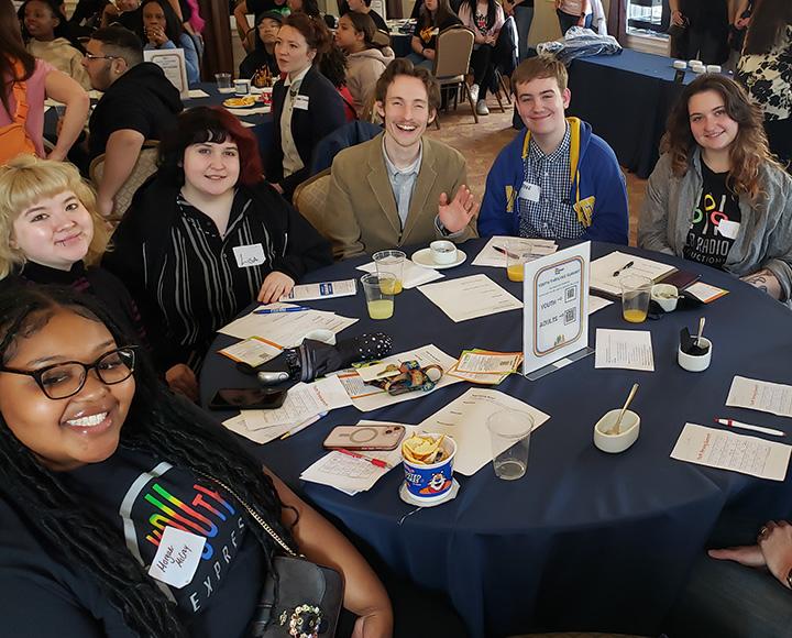 A group of students sit around a table