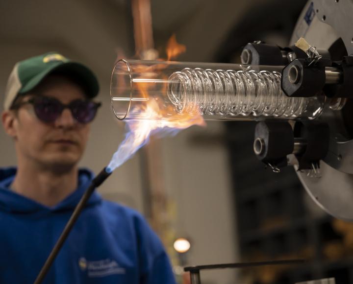 Ryan Tate heats up a glass apparatus with a blowtorch