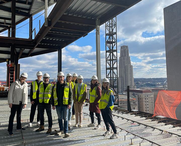 Students in yellow vests on the campus recreation center construction site