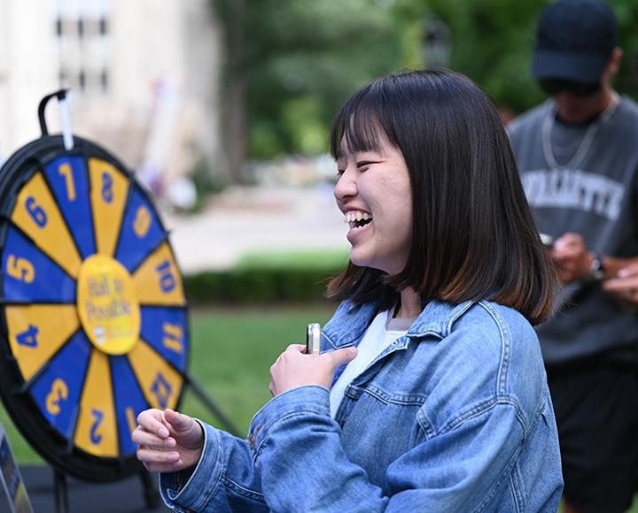 A person laughs as they spin a prize wheel