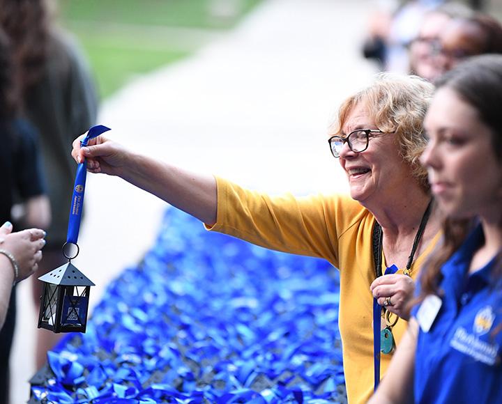 A volunteer hands out a lantern