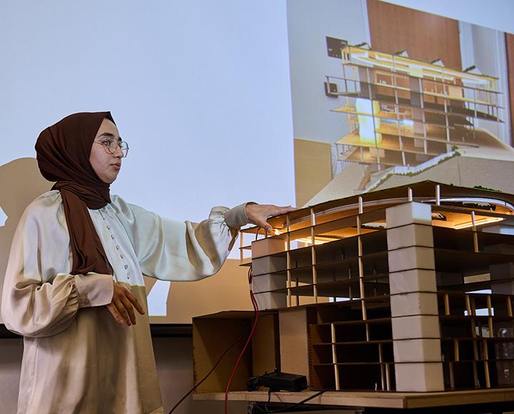A person presents the campus recreation center model