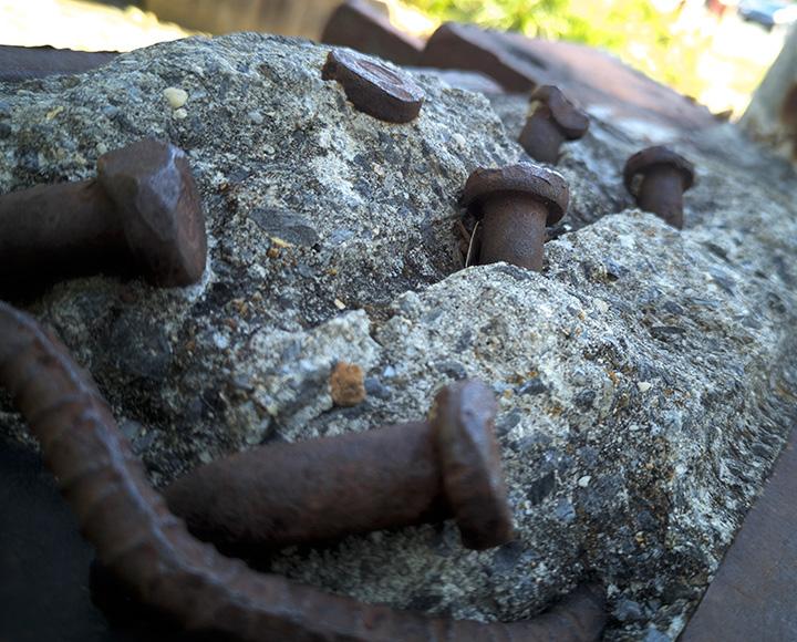 Screws stick out of concrete in the steel beam