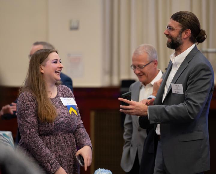 Attendees smiling during conversation