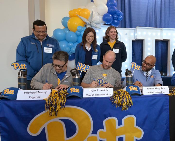 Pitt founders sign certificates at a Signing Day event