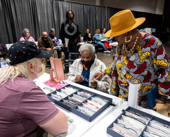 Two patients look at glasses frames in boxes