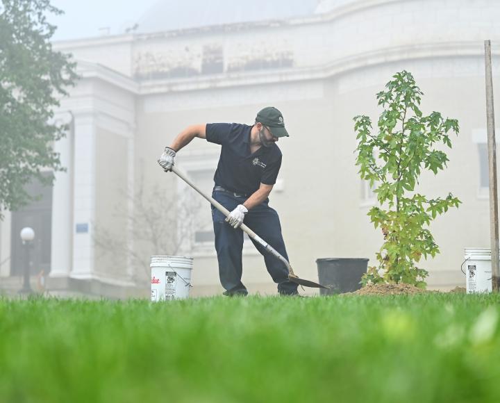 A grounds keeper digs a hole to plant new seeds at the Allegheny Observatory.