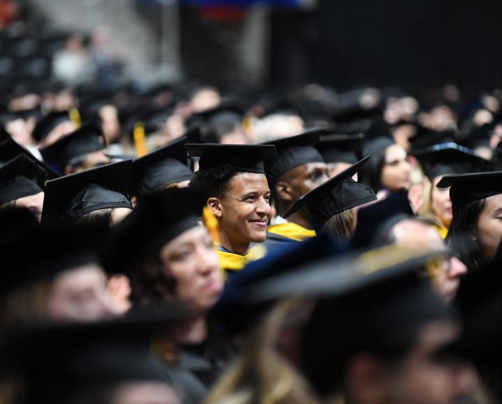 A soon-to-be graduate smiles amid the crowd.
