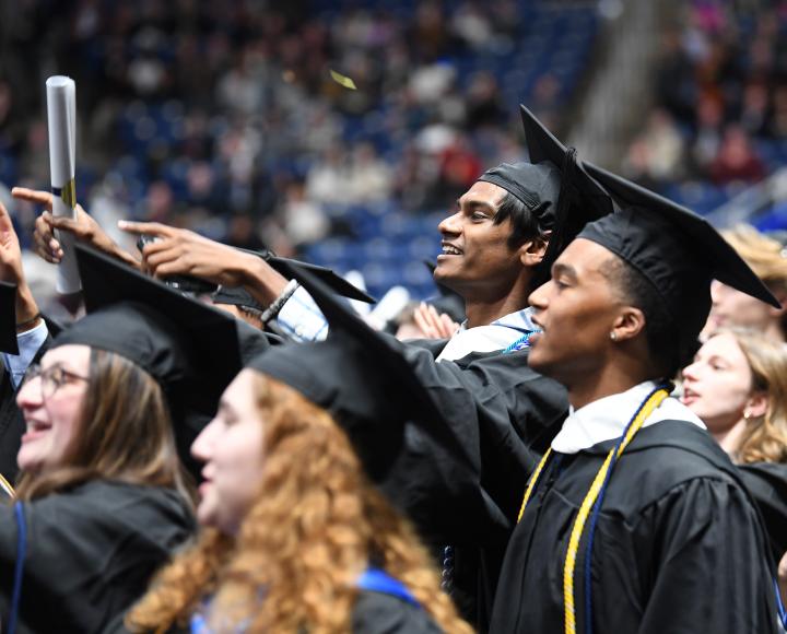 Graduates smile while holding their diplomas and singing "Sweet Caroline," the institution's unofficial song, often performed during University athletic events and alumni functions.