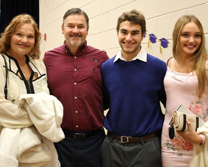 A graduate poses with loved ones during the Pitt-Greensburg winter commencement celebration.