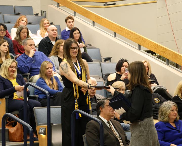 A Pitt-Greensburg graduate stands to receive their diploma.
