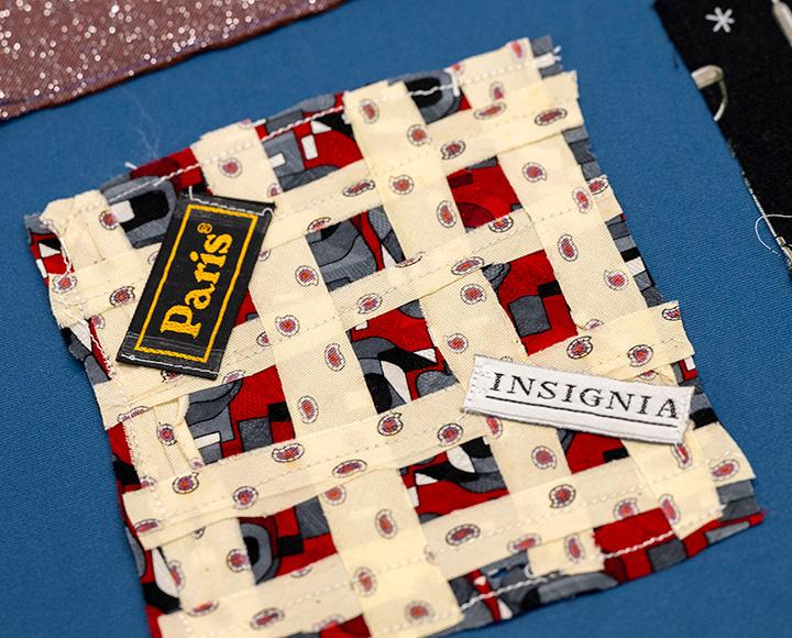A quilted square with tags that read Paris and Insignia.