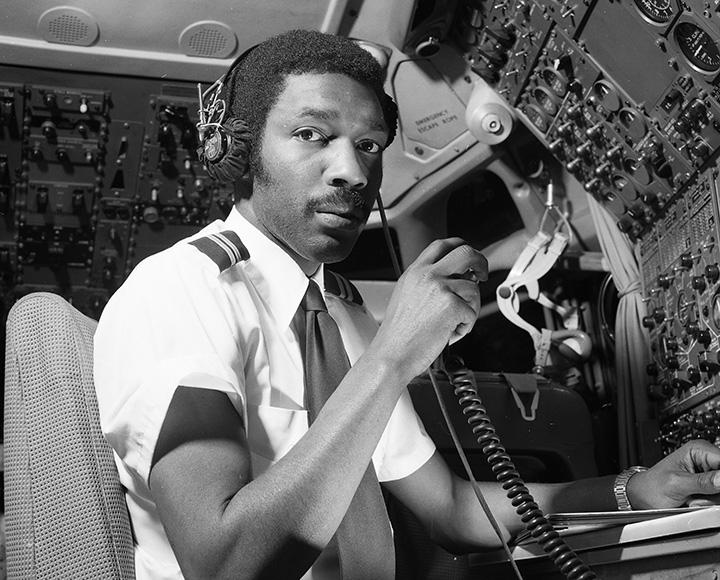 A pilot uses a radio in the cockpit