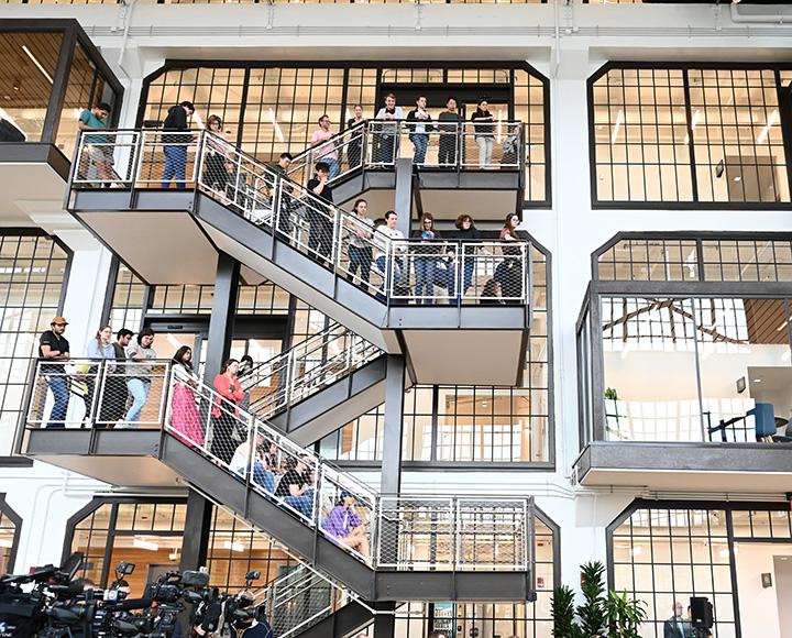 People line up on a winding staircase to watch the address.