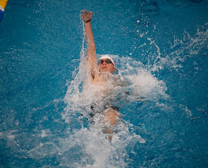 A swimmer backstrokes in a pool.