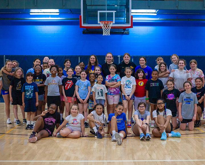 Pitt Lacrosse players pose with young girl lacrosse players