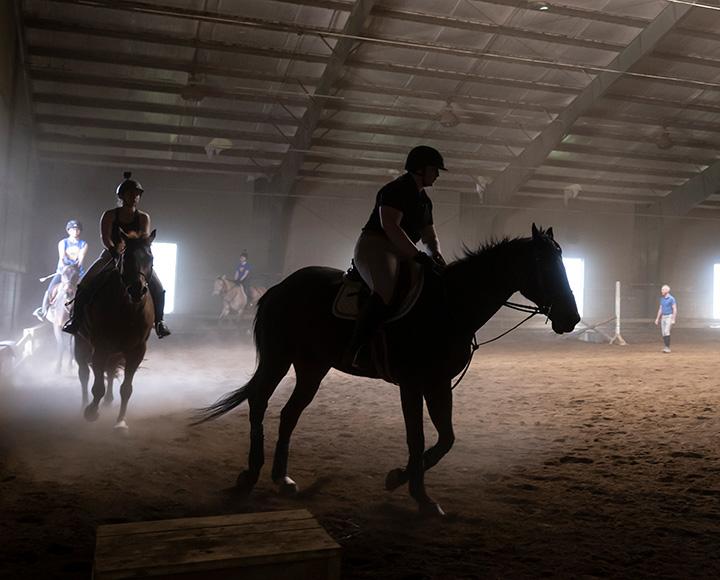Riders on horseback in a building