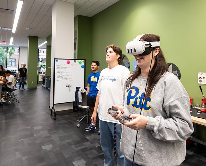 Student wearing a VR headset with controllers in her hands