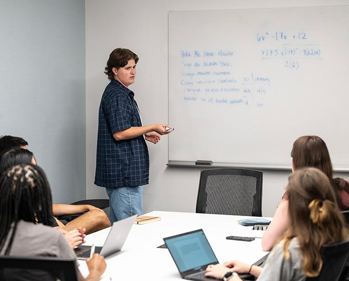 Students write on a white board around