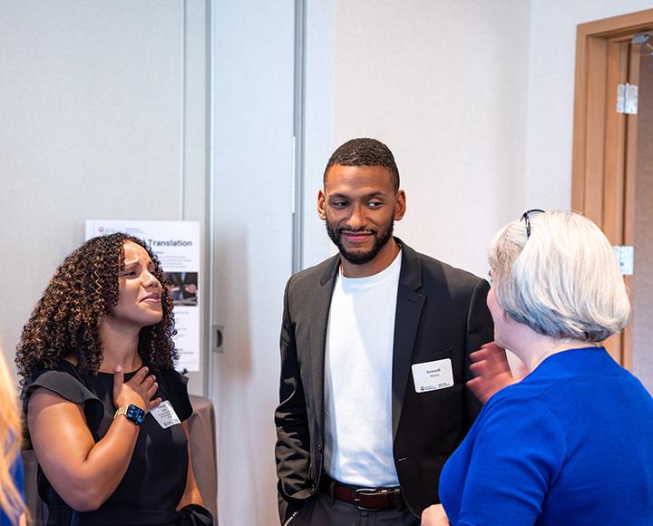 Three alumni speaking with each other