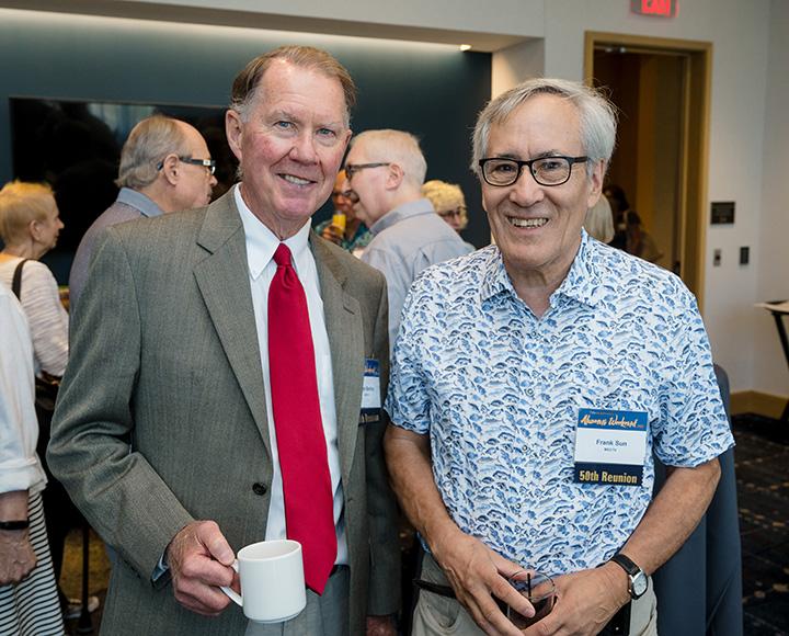 Two alumni smile