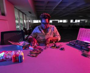A woman builds a robot at a table