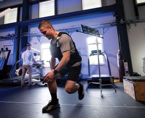 A person in athletic clothing exercising in a research lab